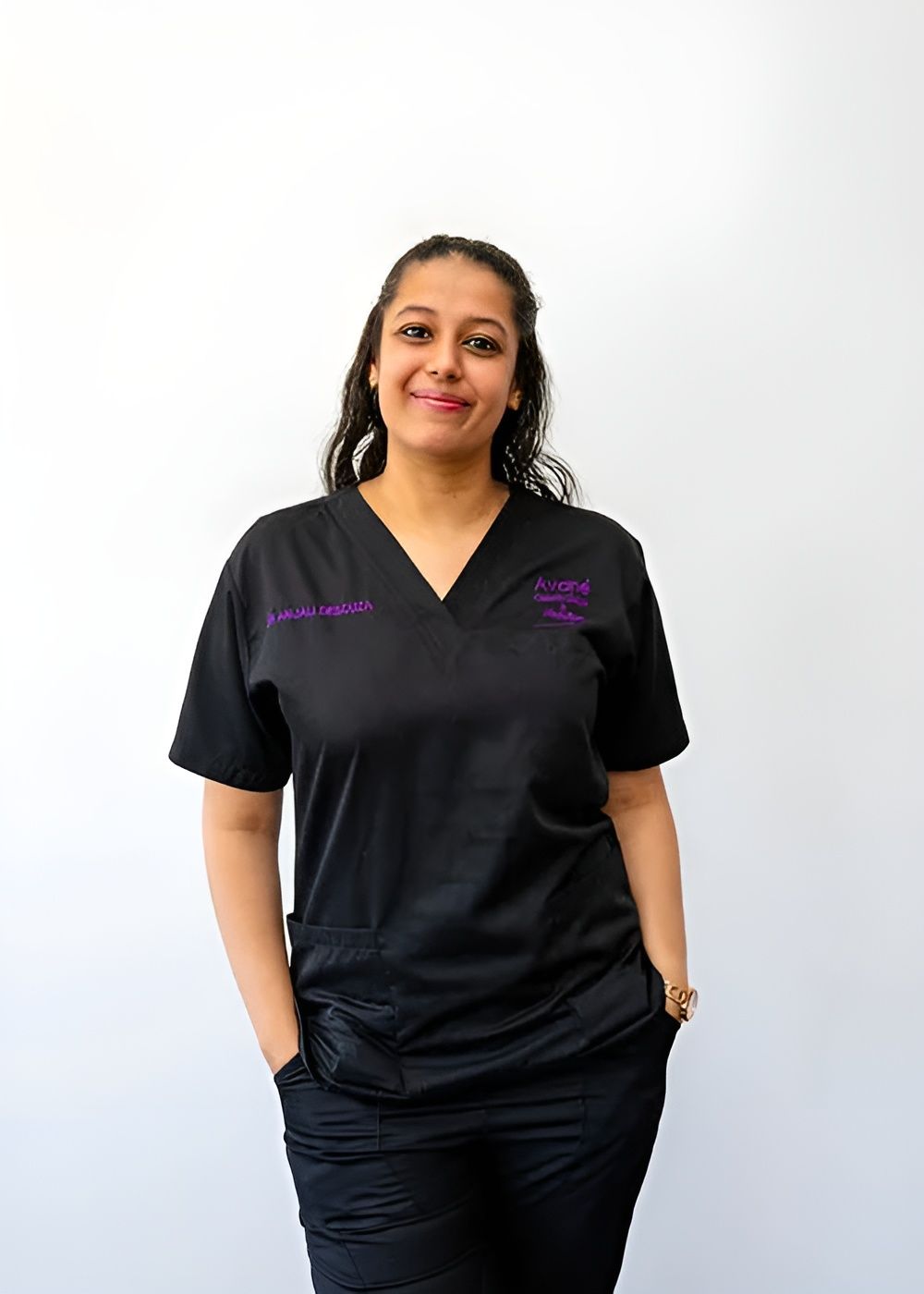 Healthcare professional in black uniform, smiling.