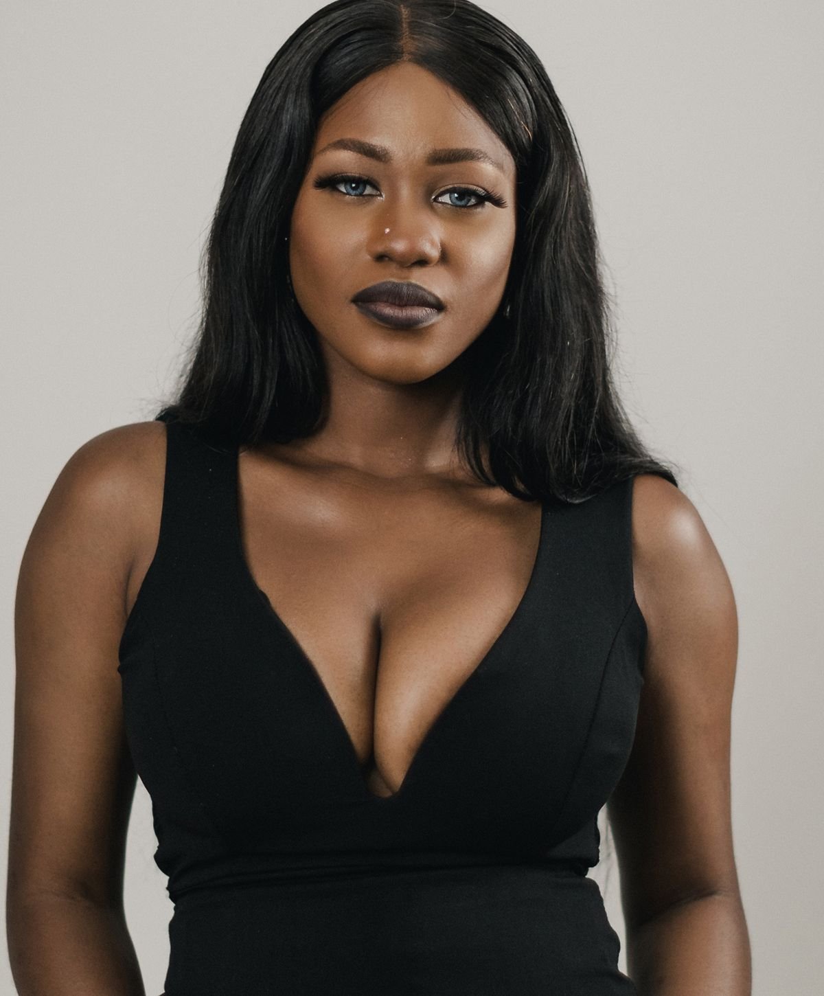 Woman with braided hair displaying gold jewelry.
