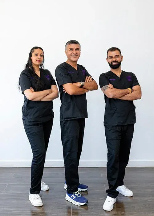 Medical professionals posing together in clinic attire.